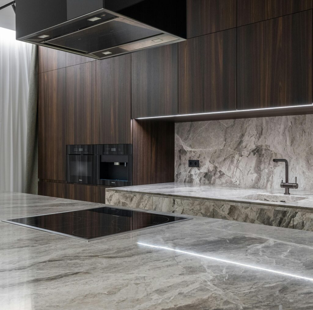 Interior design of spacious stylish modern kitchen with induction stove and air extraction system with wooden cupboards